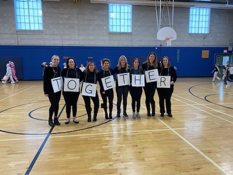 Teachers dressed as scrabble pieces spelling out TOGETHER