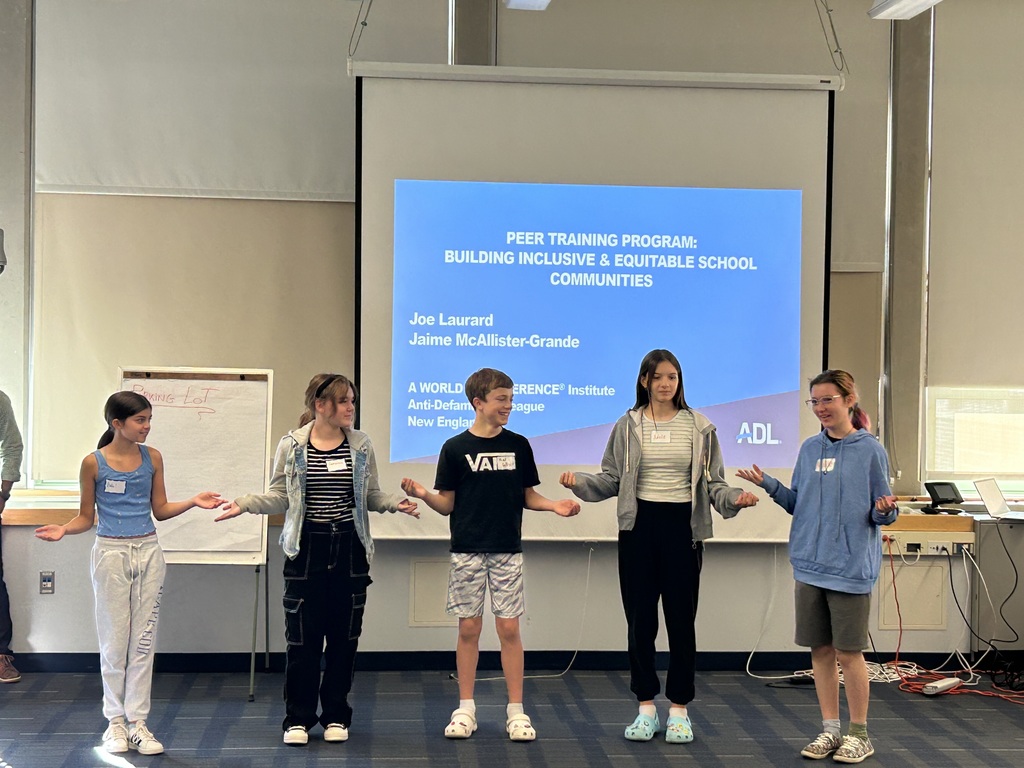 Five students standing with their hands connected during a Peer Leader Training